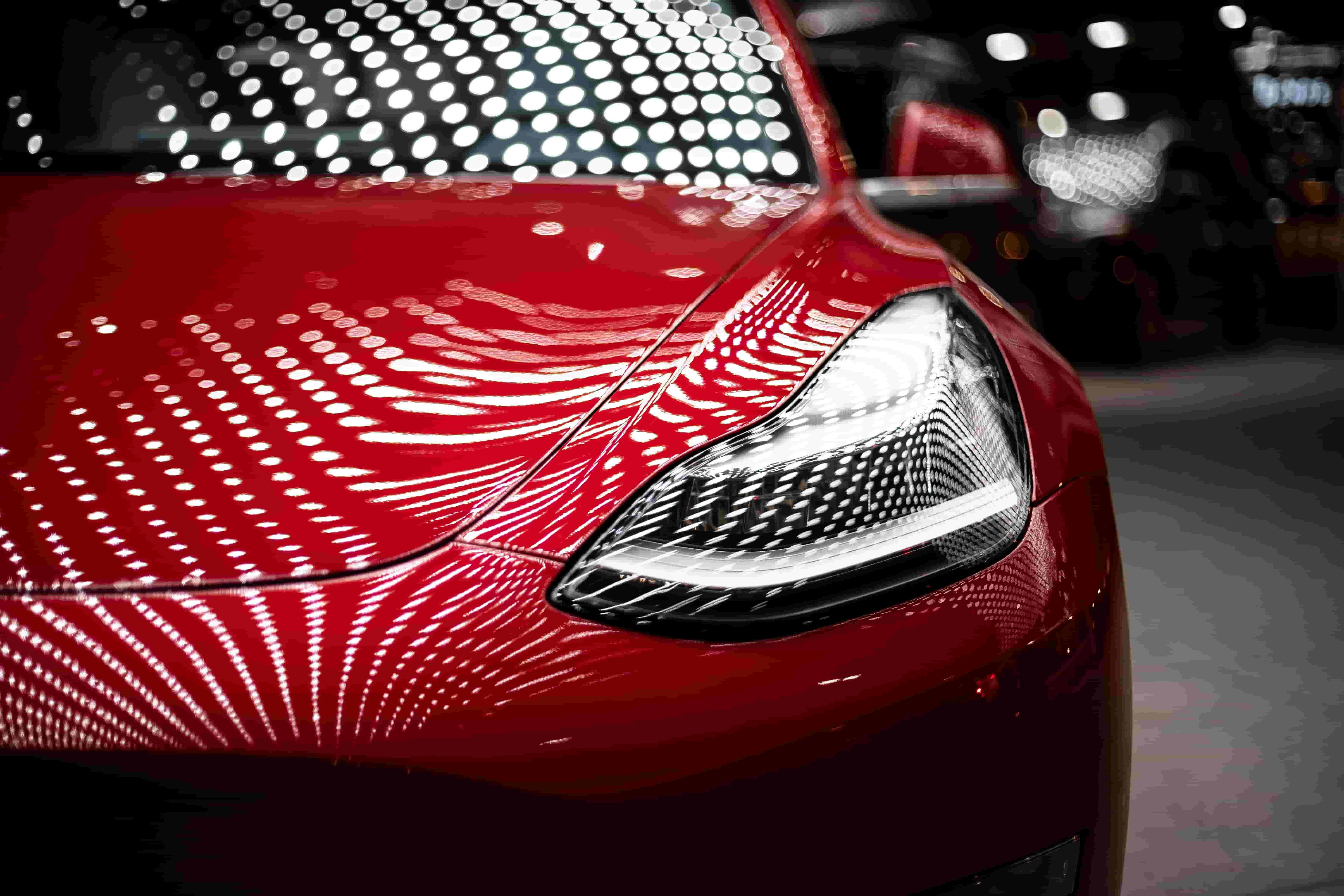 Close-up photo of the hood of a Tesla Roadster, an eco-friendly car.